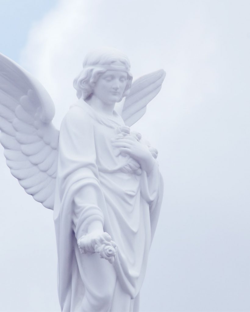 Statue of a winged angel holding posies of flowers